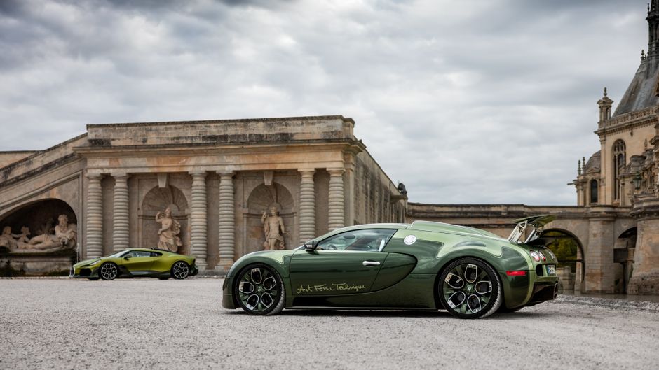 Two luxury sports cars parked near historic architecture with sculptures.