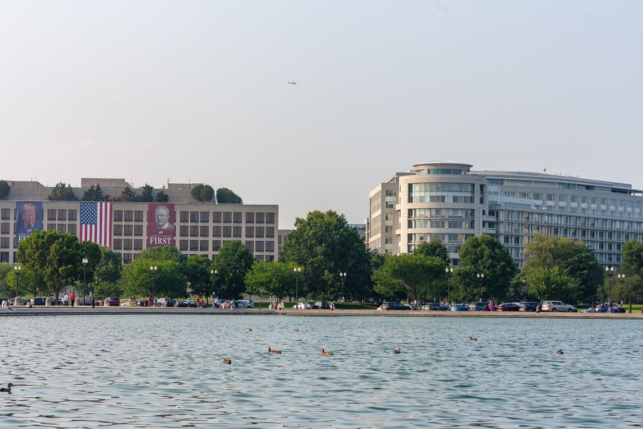 Scenic view of waterfront and modern buildings in Washington D.C. with calm waters and clear sky.