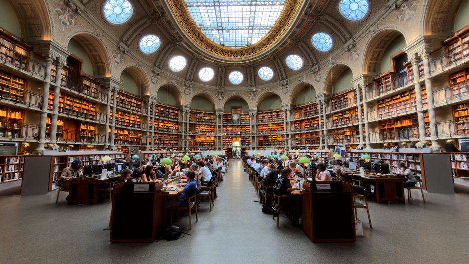 Panoramic view of the grand reading room Salle Ovale in Paris, capturing symmetry and architectural elegance.