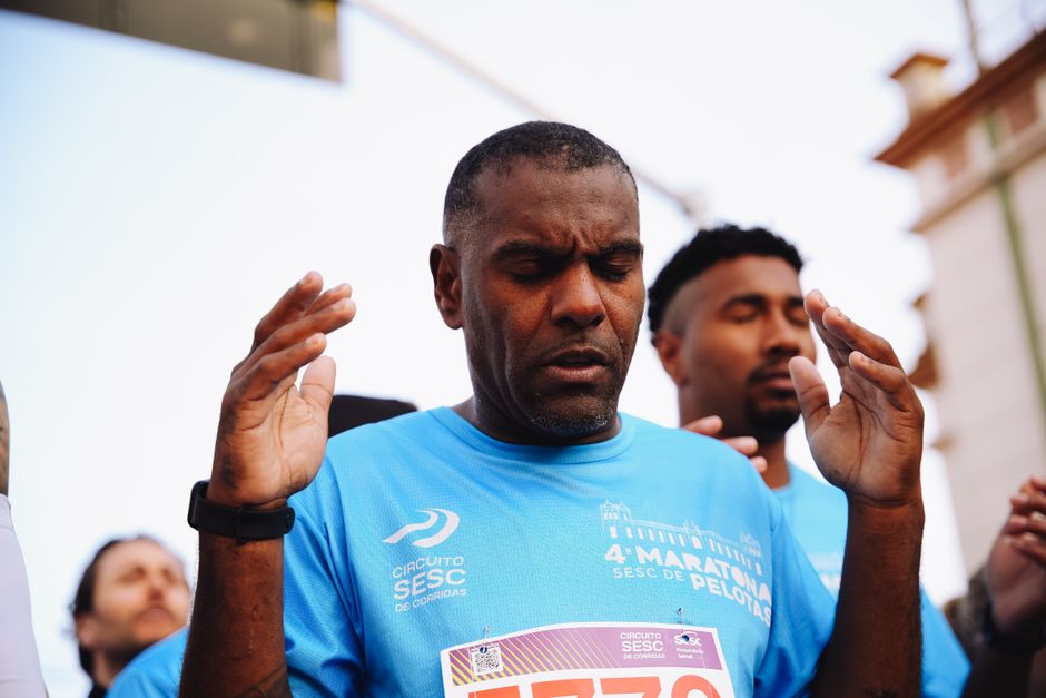 Runner preparing with focus before the race at a marathon event, with hands raised.