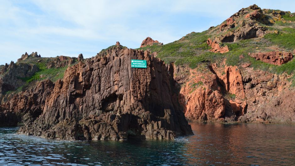 Dramatic rocky shoreline of Scandola Nature Reserve in Corsica, France, during summer.