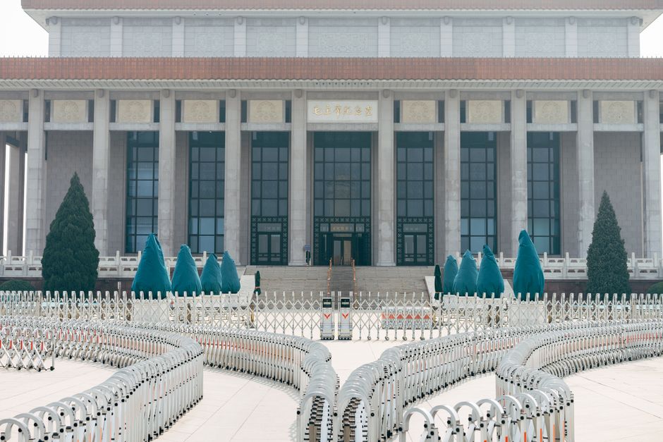 View of the historic building with grand columns and security barriers in an urban setting.