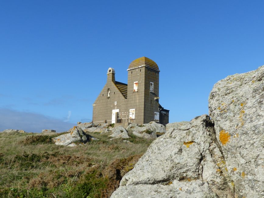 Low angle exterior of aged Vigie de la Romaine house located on rocky hill in Le Croisic town against cloudless blue sky