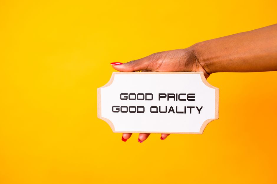 A hand holding a sign with 'Good Price Good Quality' against a vibrant yellow background.