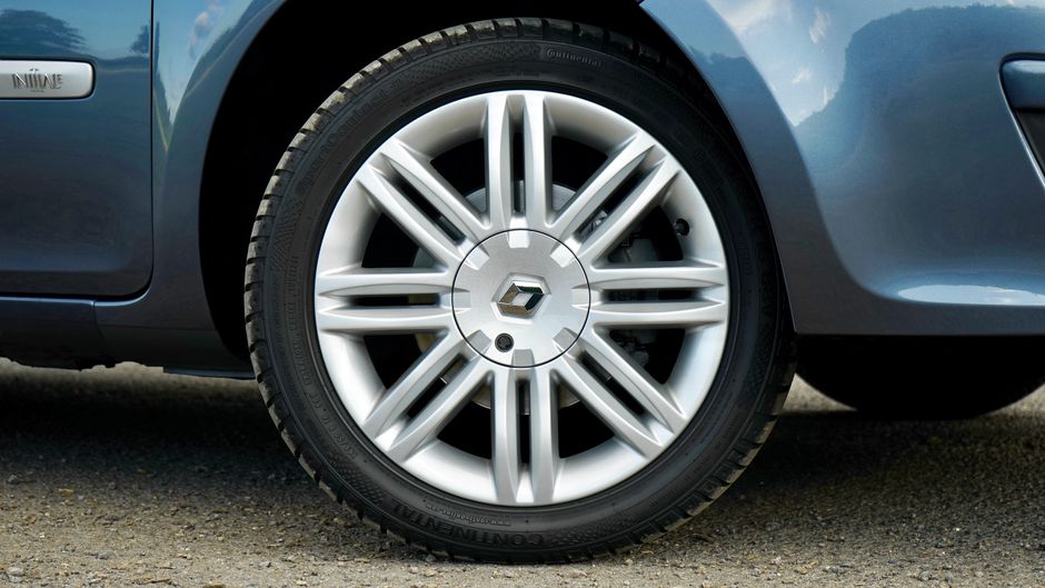 Detailed close-up of a car wheel with a silver alloy rim on a parked vehicle.