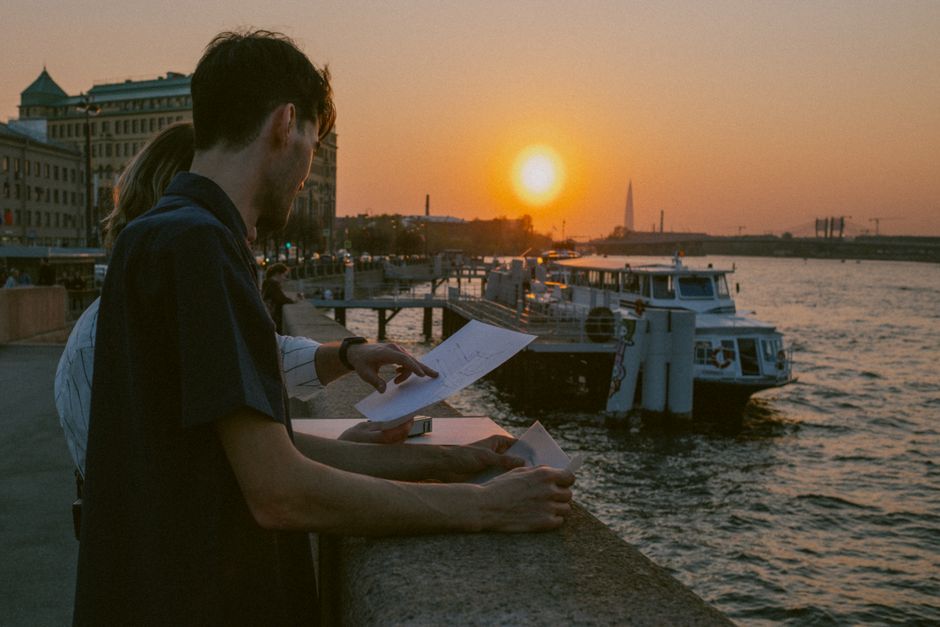 Urban scene with people discussing plans at sunset by the waterfront promenade.