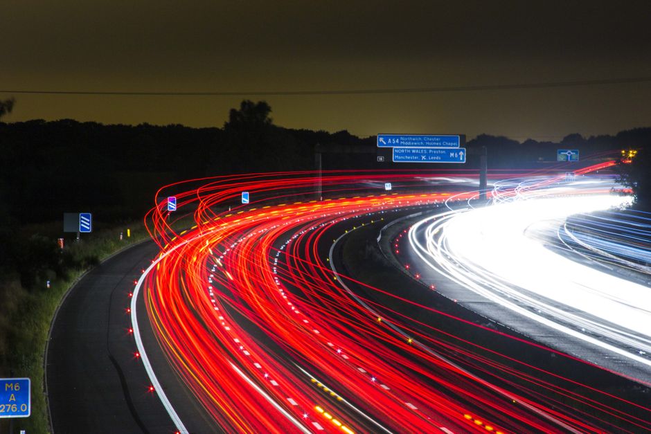 Long exposure shot of a highway at night with striking light trails.